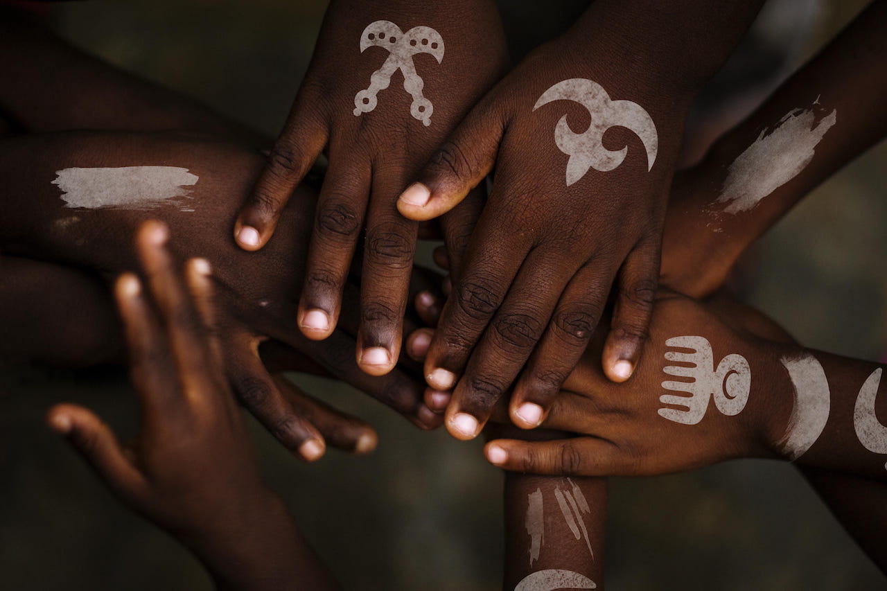 A group of hands with white tattoos on them