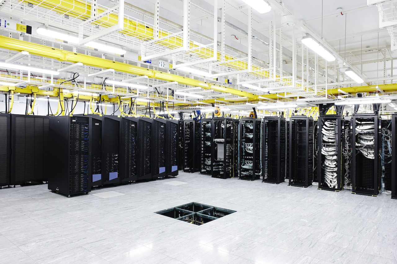 Data center room with many black servers.