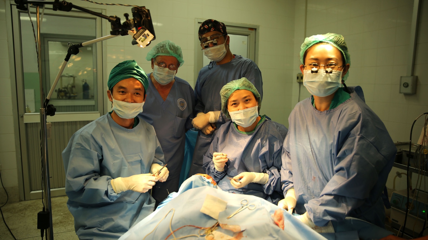 Dr Indara (far left) and the Thai surgeon team perform a surgery at Oudomxay Provincial Hospital