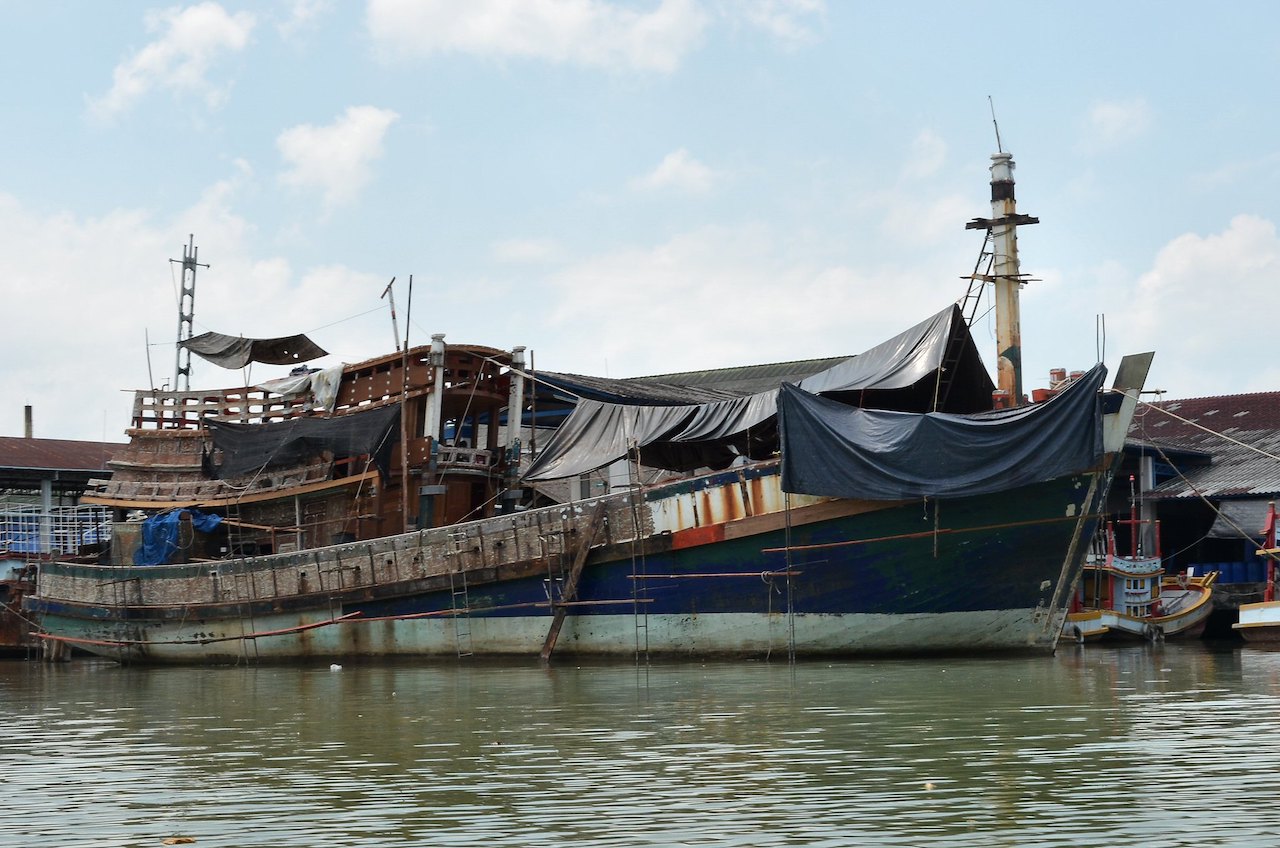 Fishing vessel tied up at dock at the mouth of the Kra Buri River in Ranong, on the west coast of Thailand.