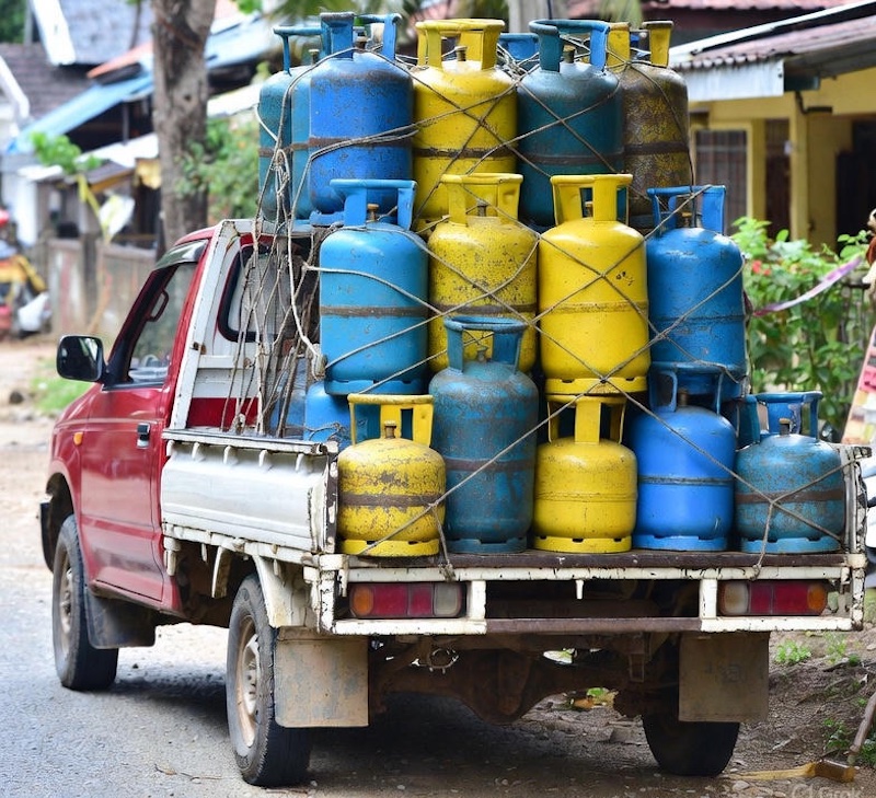 Old pickup truck carrying LPG gas cylinders in Thailand.
