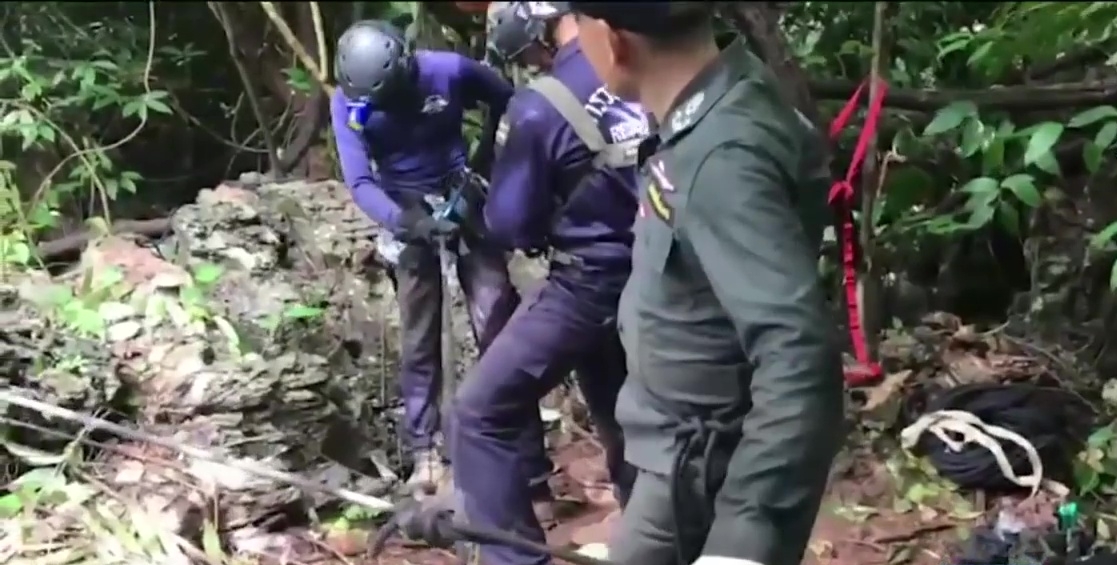 Police Aerial Reinforcement Unit personnel search for an entrance to the Tham Luang cave