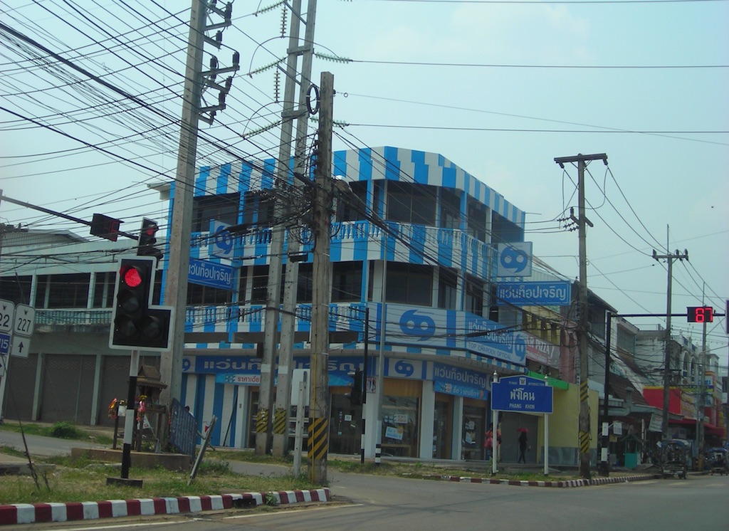 Street with low-hanging power line cables and buildings in Sakon Nakhon