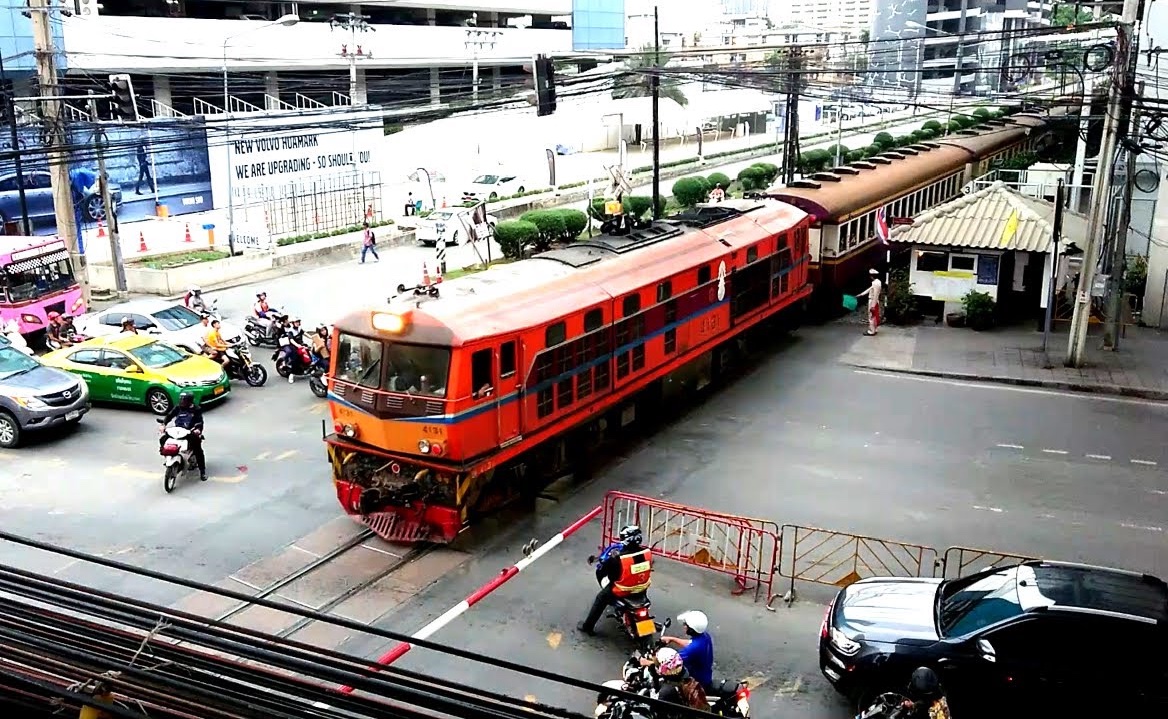 A train crossing a railroad crossing in Bangkok.